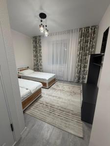 a bedroom with two beds and a television in it at Kol-Ukok Hotel in Bol'shevik