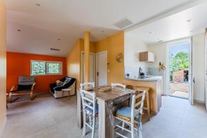 a kitchen with orange walls and a table and chairs at Maison de Charme in Mimizan-Plage