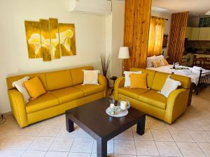 a living room with two yellow couches and a table at Amisiana Green Oasis in Amisianá