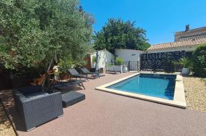 a backyard with a swimming pool with chairs and a house at Escapade à Saint-Saturnin-les-Avignon in Jonquerettes