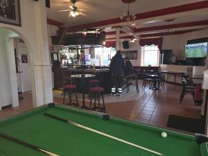 a pool table in a room with a bar at Waverley Hotel in Bonnyrigg