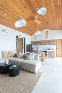 a living room with a couch and a kitchen at Siam Mila Villas in Srithanu