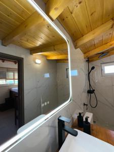 a bathroom with a mirror and a sink at Luxury Beach Villa in Skála