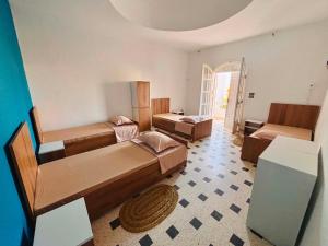a room with two beds and a living room at Wostel Djerba Downtown in Houmt Souk
