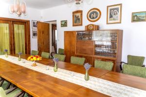 a dining room with a long wooden table and chairs at Vila Vlasta in Bruntál