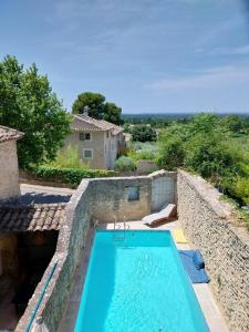 a swimming pool in a stone wall next to a house at La Villa 1777 in Lagnes