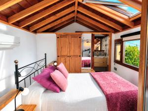 a bedroom with a white bed with pink pillows at Los Nacientes Vega in Los Sauces