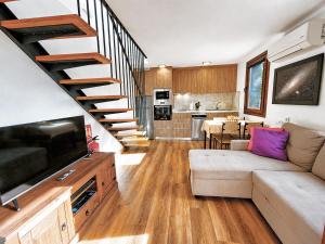 a living room with a couch and a staircase at Los Nacientes Vega in Los Sauces +18 photos