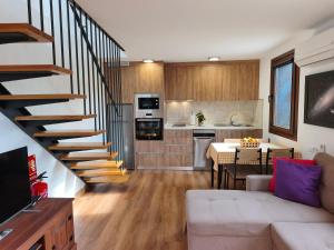 a living room with a staircase and a kitchen at Los Nacientes Vega in Los Sauces