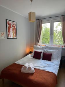 a bedroom with a large bed with towels on it at Przytulne mieszkanie blisko morza in Gdańsk