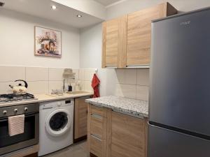 a kitchen with a refrigerator and a dishwasher at Przytulne mieszkanie blisko morza in Gdańsk