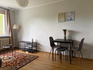 a living room with a table and chairs in a room at Przytulne mieszkanie blisko morza in Gdańsk