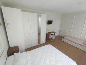 a white bedroom with a bed and a desk at El Sol de la Paz in Haro