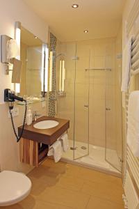 uma casa de banho com um lavatório e um chuveiro em Hotel Stadt Pasing em Munique