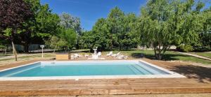 a swimming pool in a yard with chairs and trees at Suite Millésime du Château - Proche Océan in Gaillan-en-Médoc