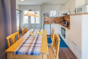 a kitchen with a wooden table and chairs in a kitchen at Ferienhaus Mackeriege in Norden