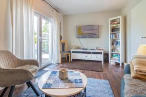 a living room with a couch and a table at Ferienhaus Mackeriege in Norden