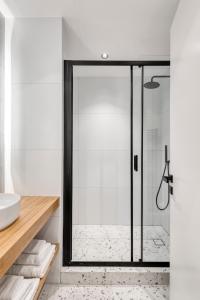 a bathroom with a shower with a glass door at Dock 38 Apartments Collection in Piraeus