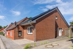 a red brick house with a lot of windows at Ferienhaus Mackeriege in Norden