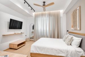 a bedroom with a bed and a flat screen tv at Dock 38 Apartments Collection in Piraeus