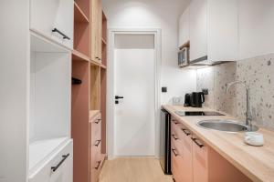 a kitchen with white cabinets and a sink at Dock 38 Apartments Collection in Piraeus +48 photos
