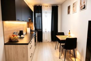 a kitchen with a counter and a table with chairs at Nowoczesny Apartament Prudnik in Prudnik +4 photos