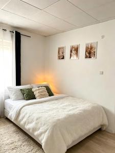a bedroom with a large white bed with two pillows at Nowoczesny Apartament Prudnik in Prudnik