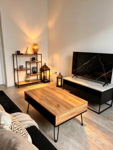 a living room with a coffee table and a flat screen tv at Nowoczesny Apartament Prudnik in Prudnik