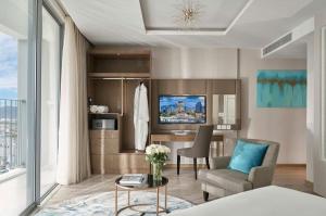 a living room with a couch chair and a television at Panorama Beach Win Nha Trang in Nha Trang