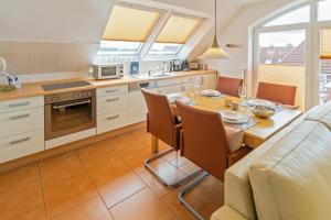 a kitchen with a table and a dining room at Exklusive Ferienwohnung Sonnenplatz 30 in Norddeich +21 photos