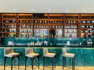 a bar in a hotel with three stools at Panorama Beach Win Nha Trang in Nha Trang