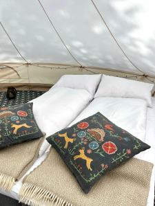 two pillows sitting on a bed in a tent at Lystang Camping & Cabins in Notodden
