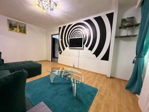 a living room with a glass coffee table in front of a wall at Hypnotic Suite 1 in Piteşti