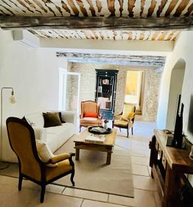 a living room with a white couch and chairs at La Villa 1777 in Lagnes