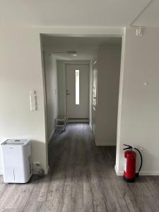 an empty room with a hallway with a fire extinguisher at Cozy apartment in Tananger close to the Airport in Tananger