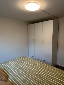 a bedroom with a bed and white cabinets at Cozy apartment in Tananger close to the Airport in Tananger