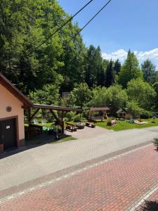 a brick patio with a picnic shelter and trees at Agroturystyka Kadłubek in Wisła