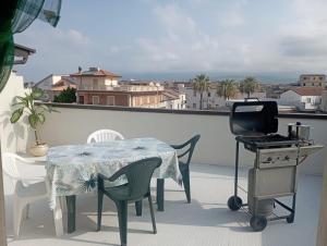 a patio with a table and a grill on a balcony at Una Terrazza sul mare in San Ferdinando +1 photo