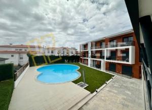 a swimming pool on the roof of a building at Vilamar - Ribamar in Ribamar