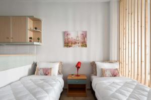 a bedroom with two beds and a red lamp on a table at Megusta Apartments Selianitika - Poolside Escape in Selianitika +24 photos