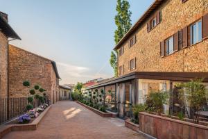an alleyway between two brick buildings with potted plants at Borgo Tre Vaselle in Torgiano
