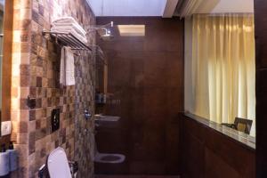 a bathroom with a shower and a toilet and a mirror at Hotel Icon in Chandīgarh +43 photos