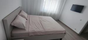 a bed with white sheets and pillows in a room at Apartament Bianco in Brăila