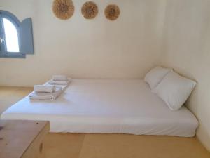 a bedroom with a white bed with towels on it at Casa Luca in Drios