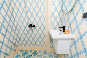 a bathroom with a white sink and blue and white tiles at KASA GUEST Tamraght in Tamraght Ouzdar +63 photos