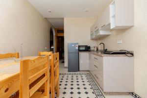 a kitchen with a refrigerator and a table at KASA GUEST Tamraght in Tamraght Ouzdar