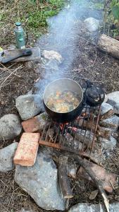 a pan of food is cooking on a grill at Refugio La Paciencia in Travesía