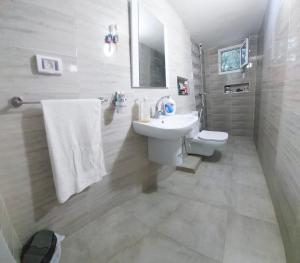 a white bathroom with a sink and a toilet at Sunrise home in Hammamet