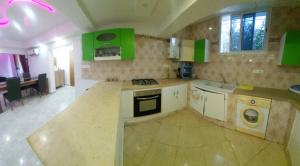a kitchen with green cabinets and a stove top oven at Sunrise home in Hammamet