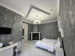 a bedroom with a bed and a desk and a tv at Global Star Hotel in Samarkand
